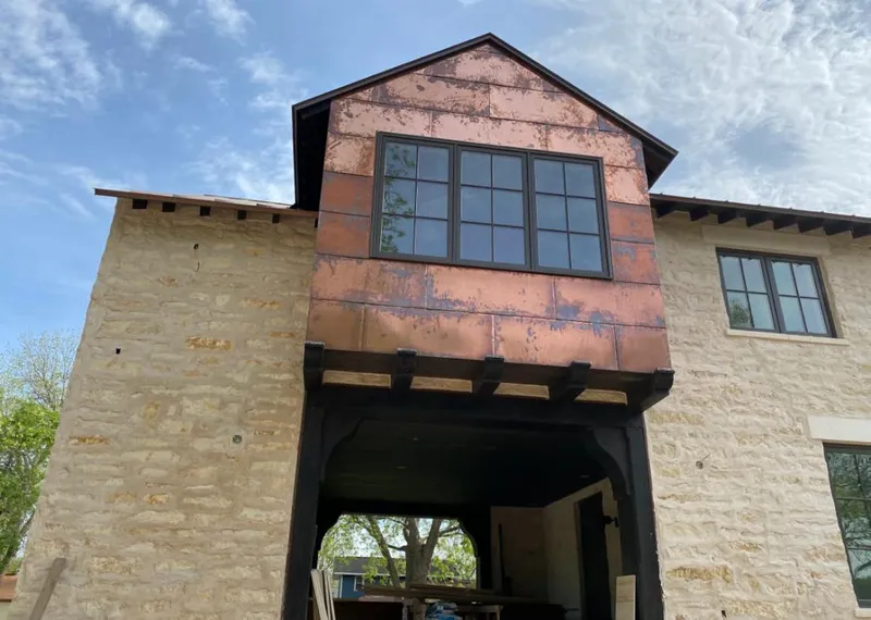 Copper metal panel facade on a stone building for Roof Repair in Gibsonville